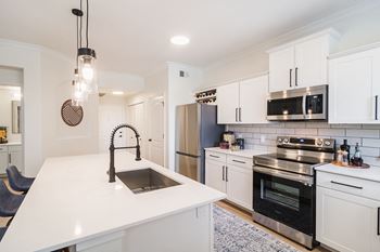 a kitchen with white cabinetry and stainless steel appliances at Terracina, Colorado